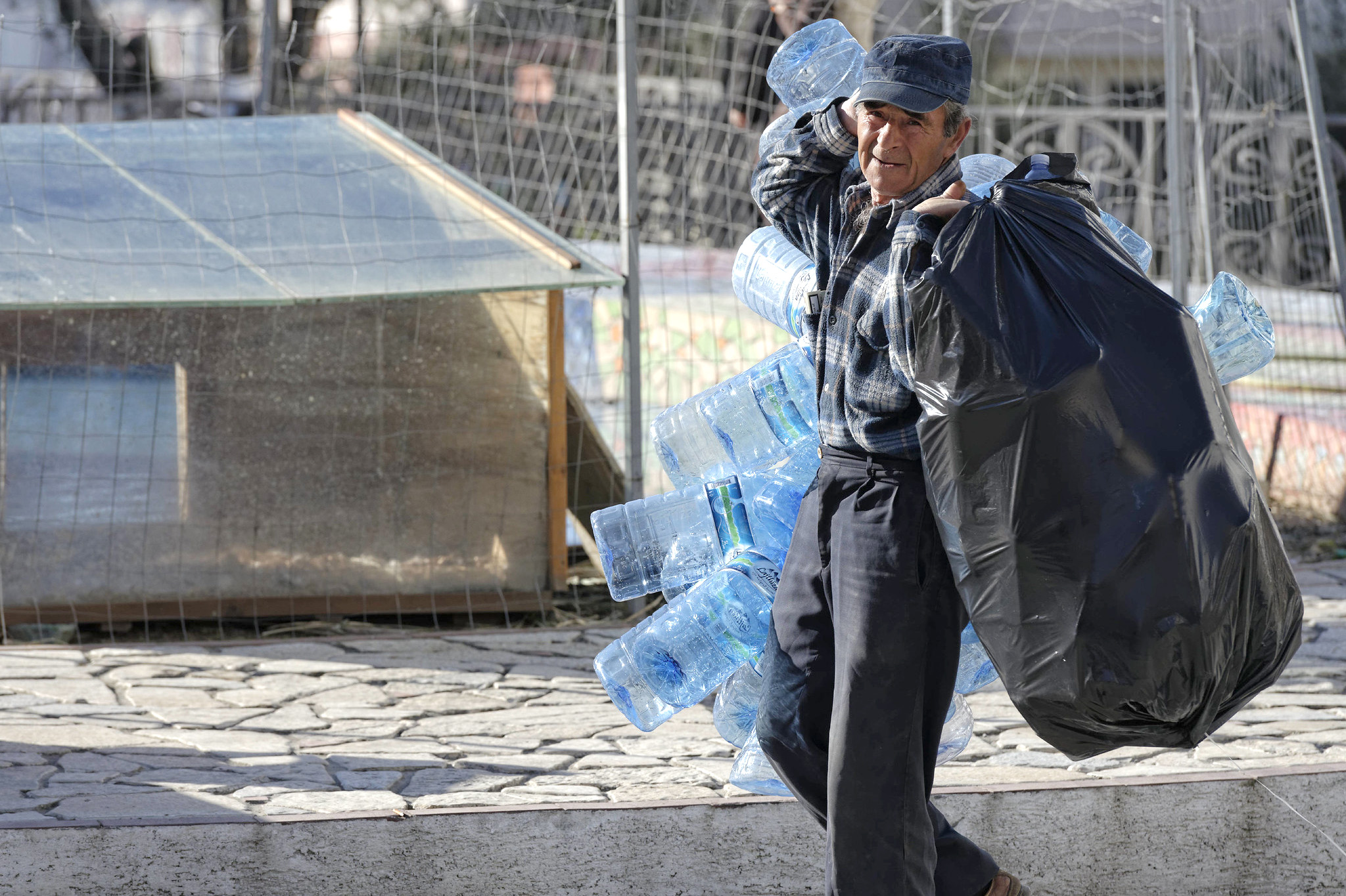 Man carrying plastic water containers. 