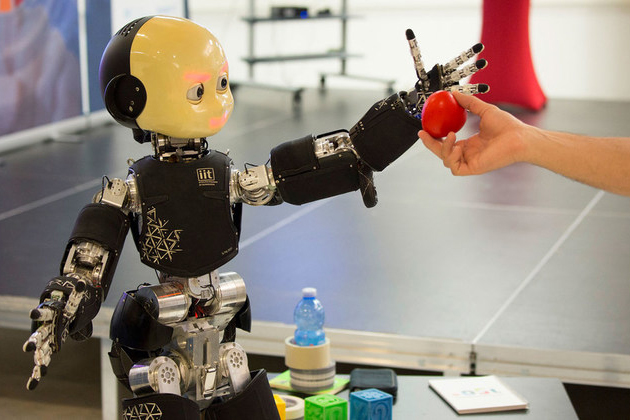 robot reaching for an apple handed by a human