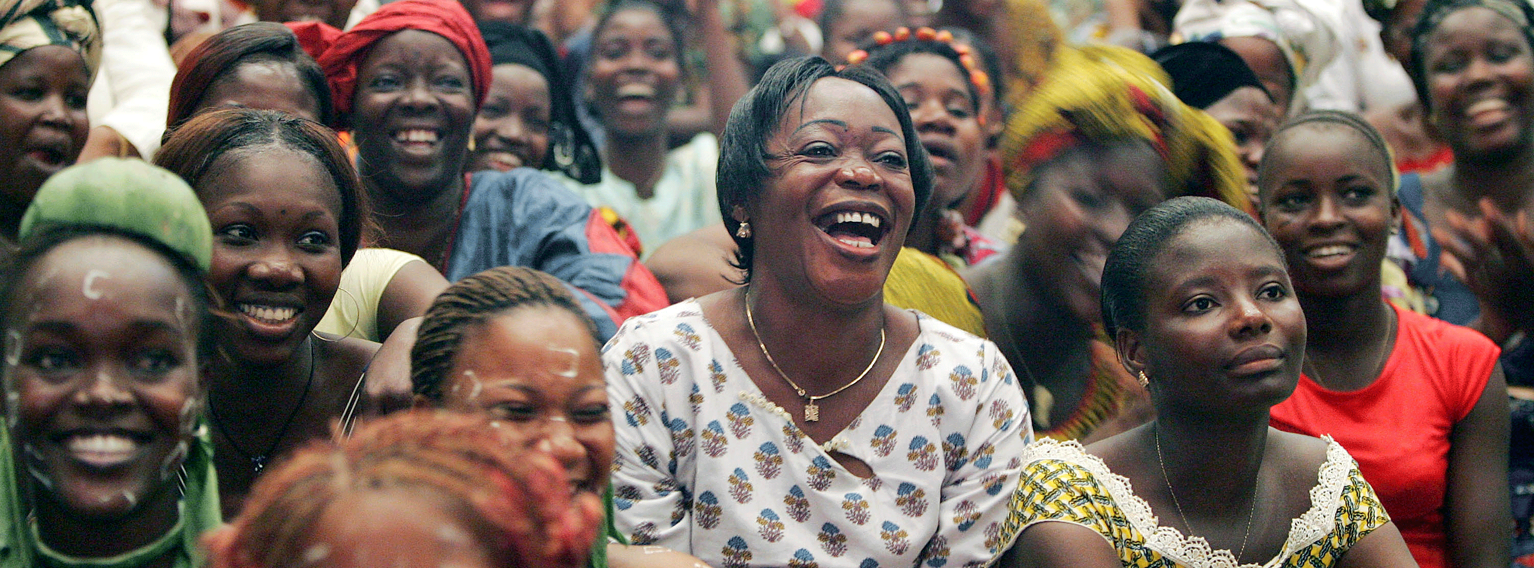 A crowd of women sitting down and laughing. 