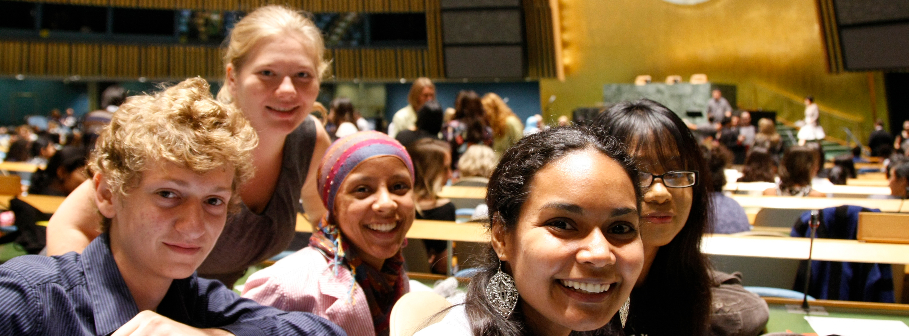 Un grupo de jóvenes sonríe desde el interior del Salón de la Asamblea General.