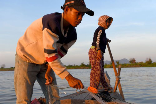 children fishing in a boat