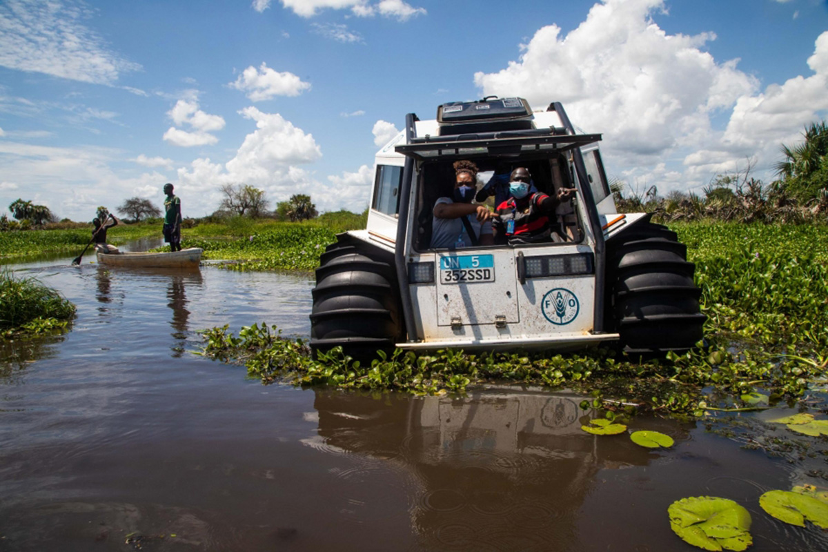 An ATV with mud tires going through flooded land