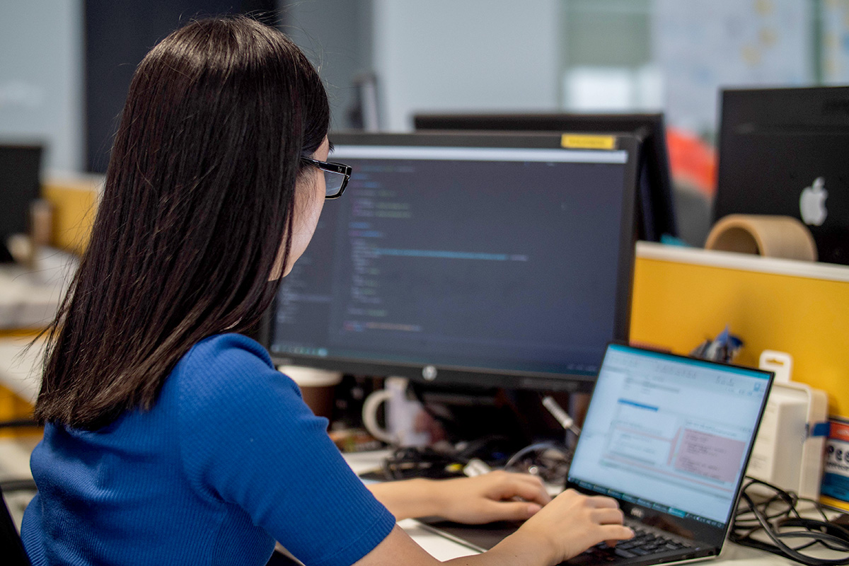 A girl sits in front of a computer. 