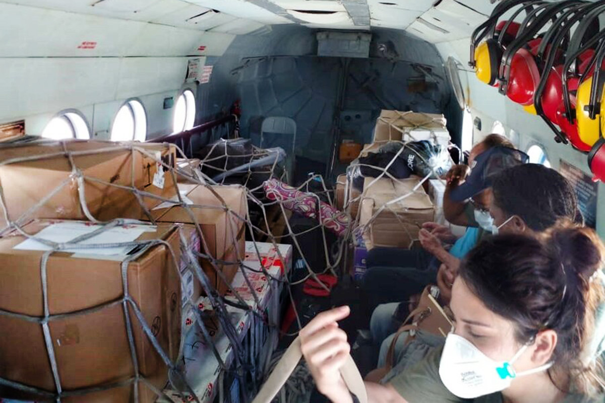 Boxed supplies and people inside a helicopter.