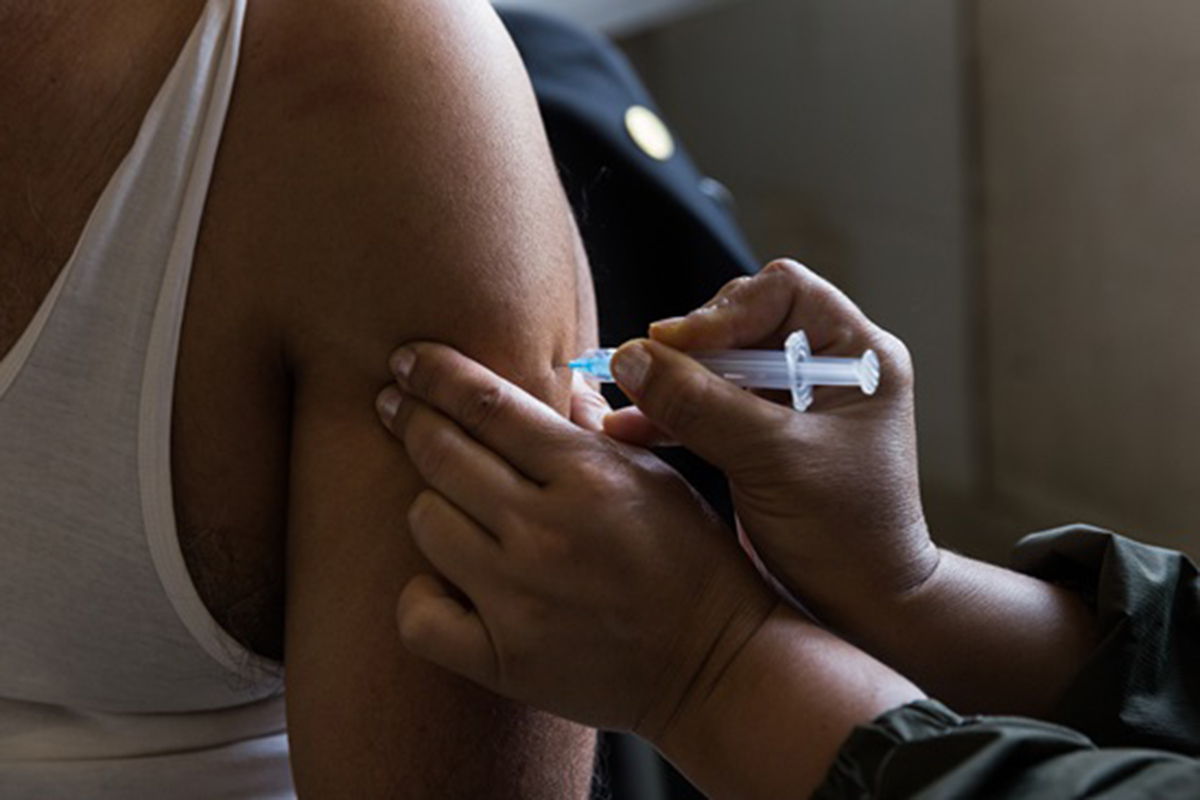 A close-up of a needle sticking a person’s arm