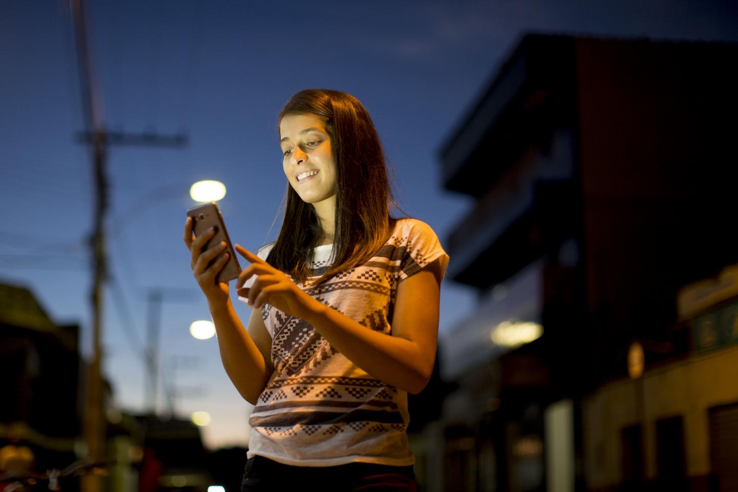 Foto de una chica con un teléfono móvil.