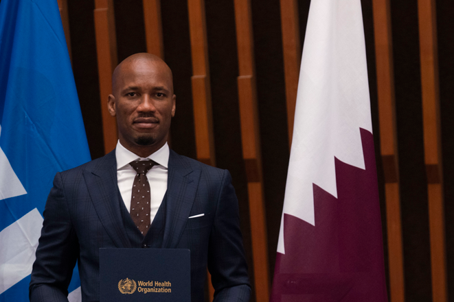 Didier Drogba holding cover with World Health Organization on it