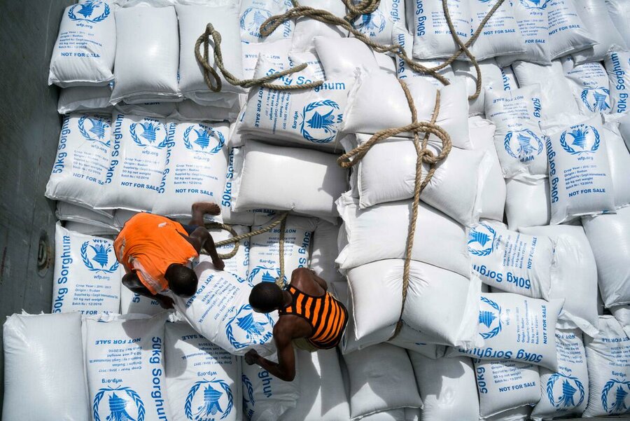 seen from above, two men unload WFP packages
