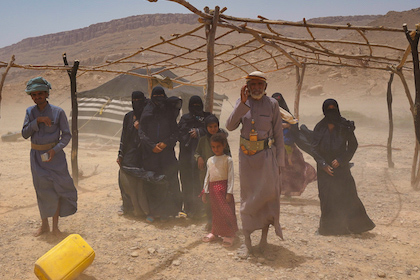 group of Yemeni people standing under incomplete shelter