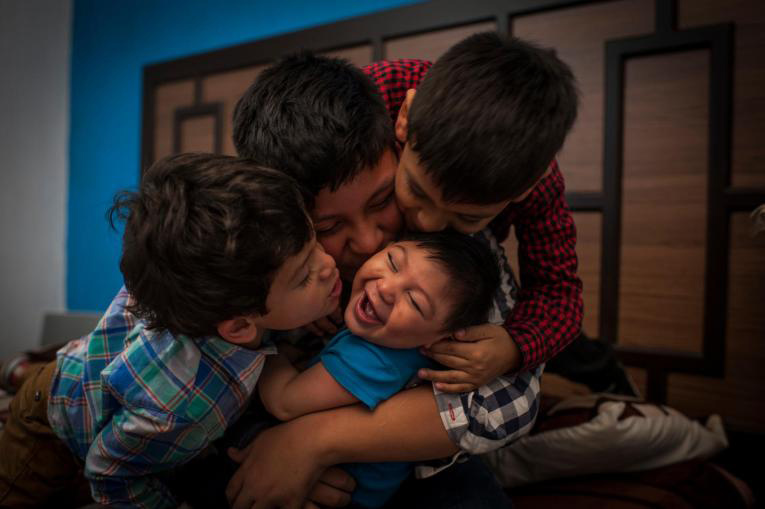 child with Zika hugged by siblings