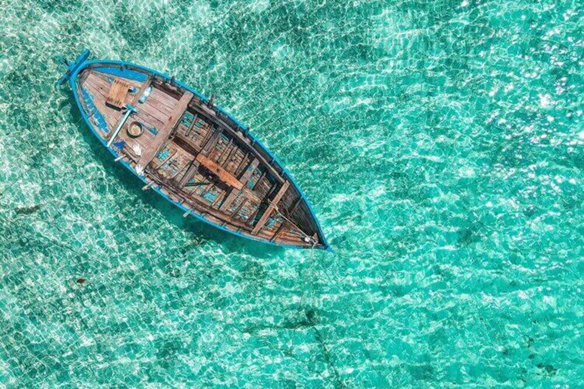 A boat at sea with empty plastic bottles inside seen from above. 