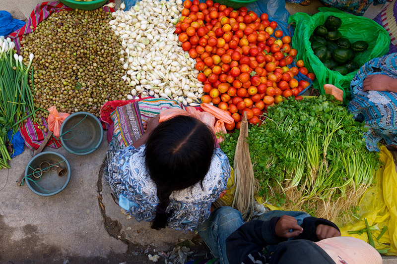 women and child with variety of produce seen from above