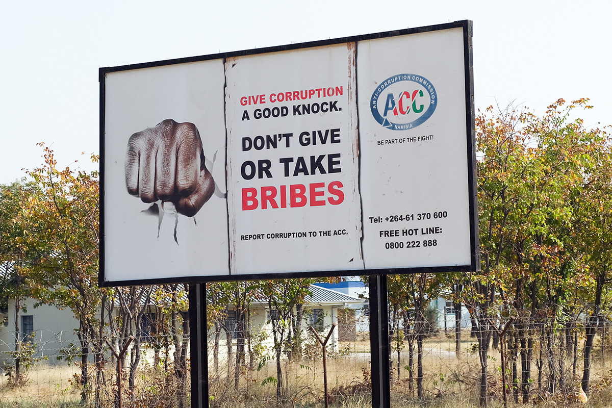 Billboard of a fist that reads “Give corruption a good knock”.