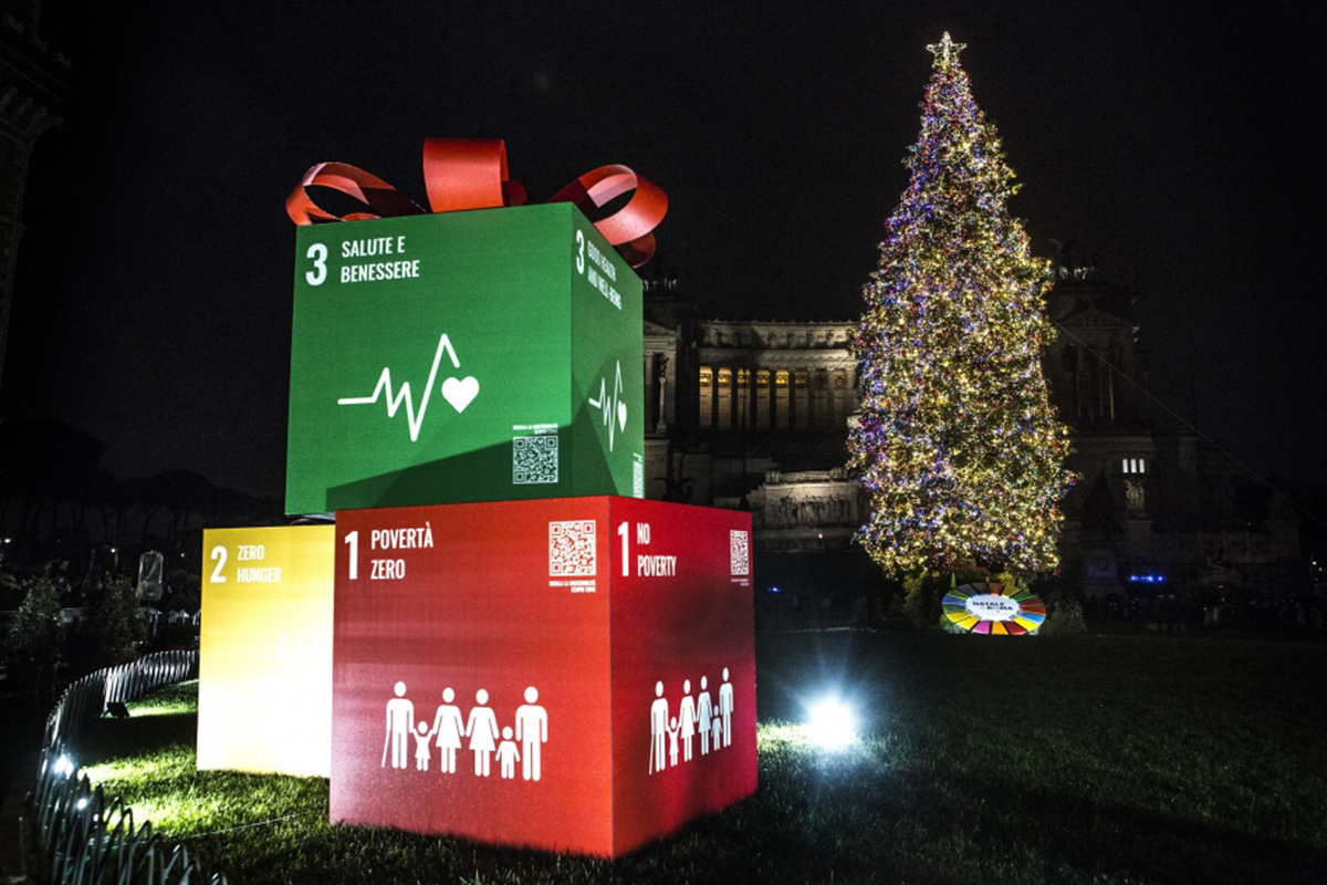 Cubes representing the SDGs with a ribbon on top by a Christmas tree.