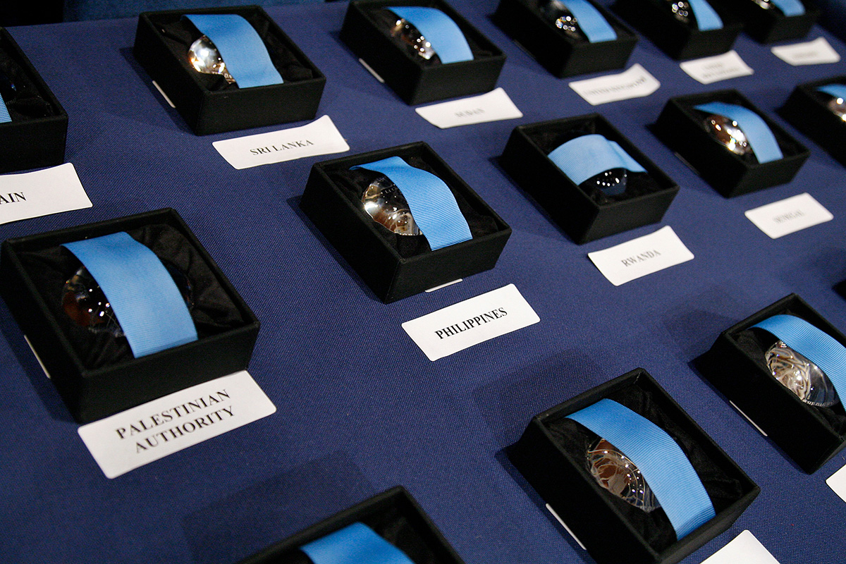 Three rows of medals in boxes with country names below them  