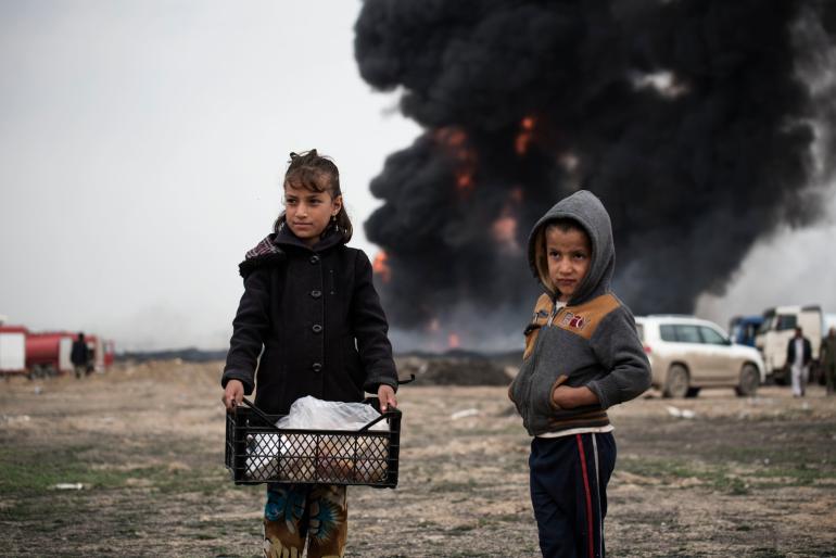 children with dark smoke in the background