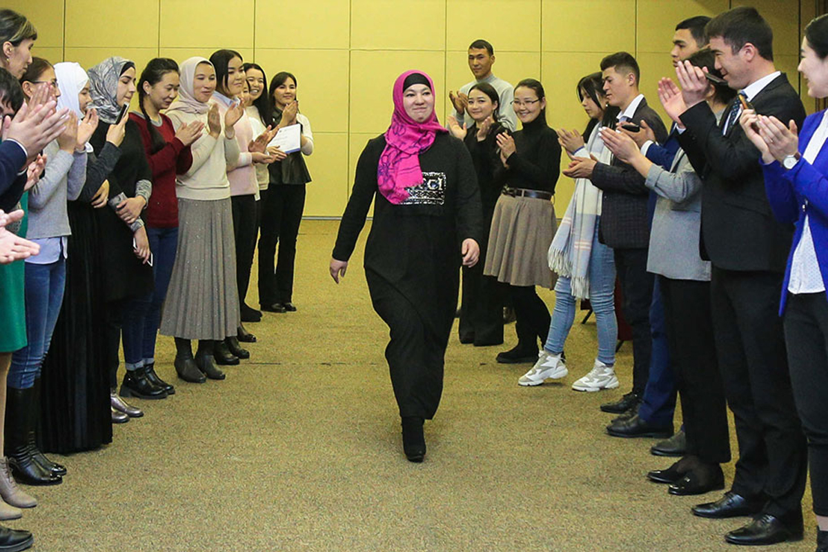 Maftuna Mavlyanova walks as people around her clap.