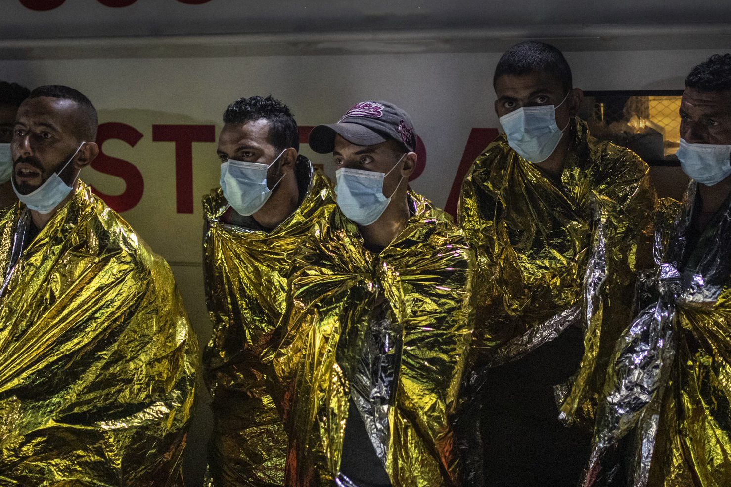 refugees wrapped in foil blankets