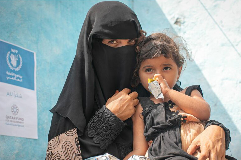 mother with child holding nutrition packet