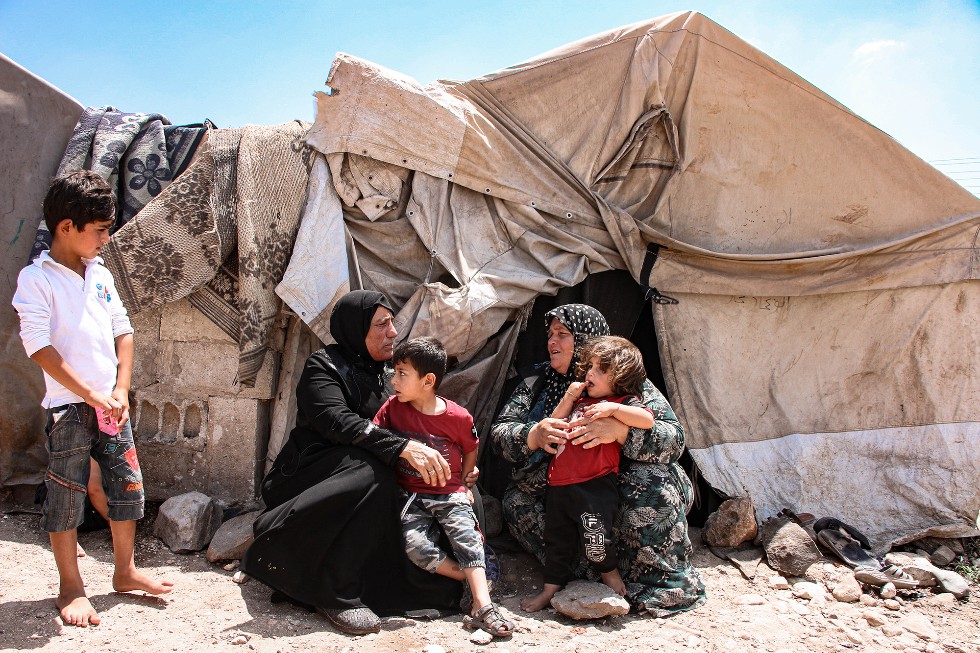 Syrian women and children in front of tent