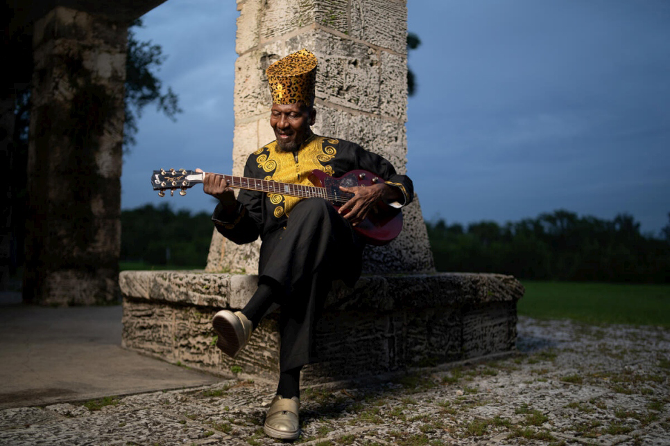 Portrait of Jimmy Cliff playing a guitar. 