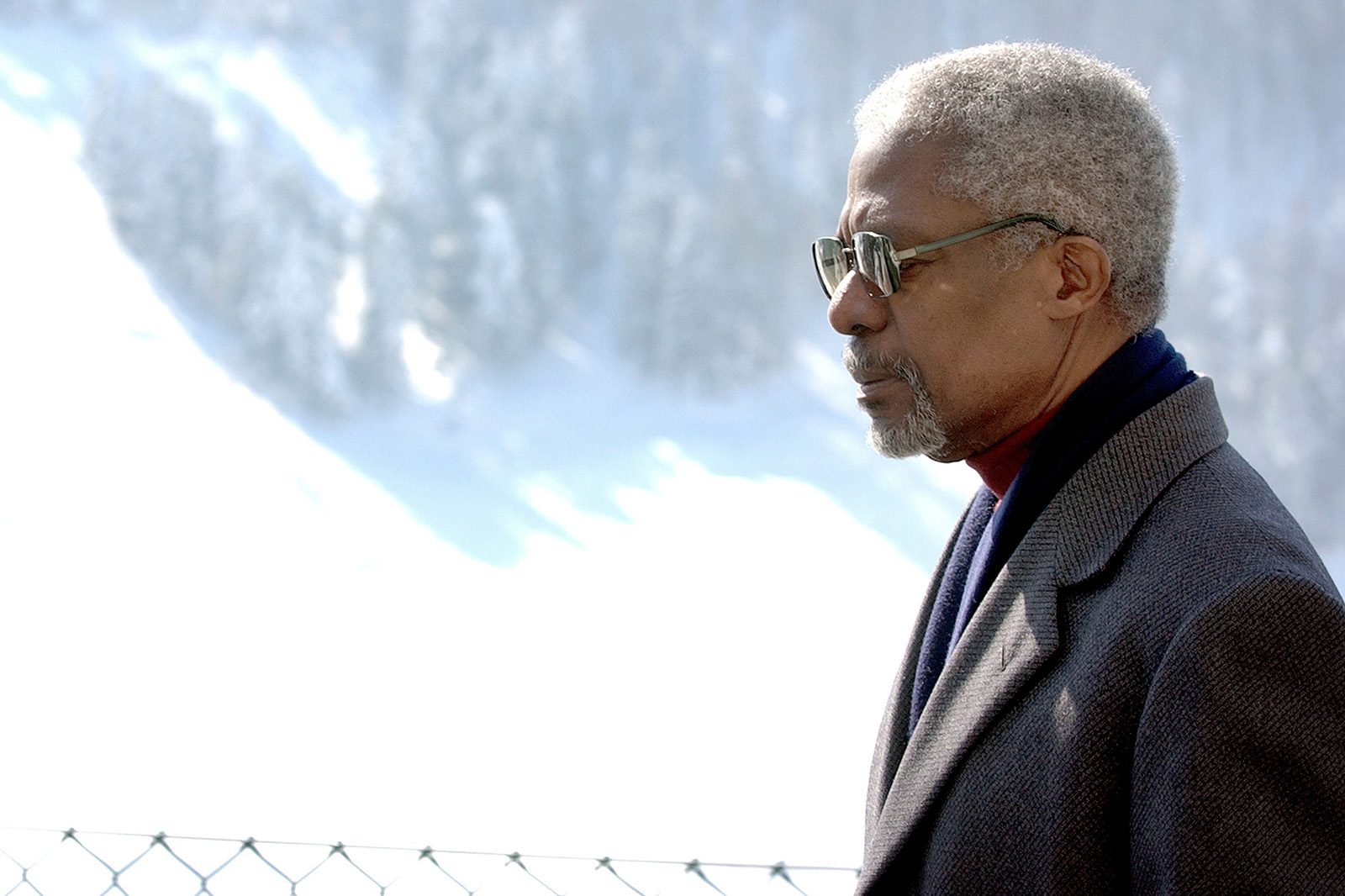 Profile portrait of Kofi Annan with a snowed mountain in the background.