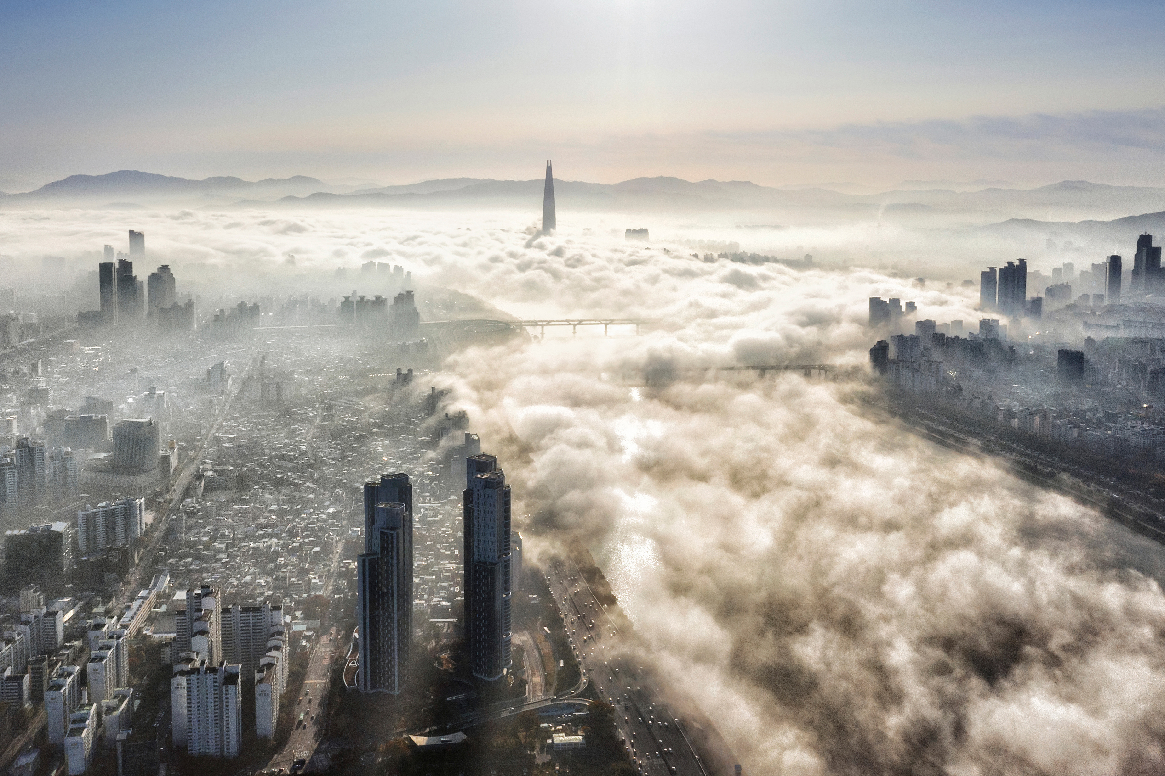 View of a city covered in clouds from above