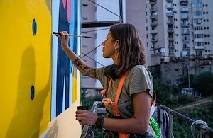 Girl painting a billboard