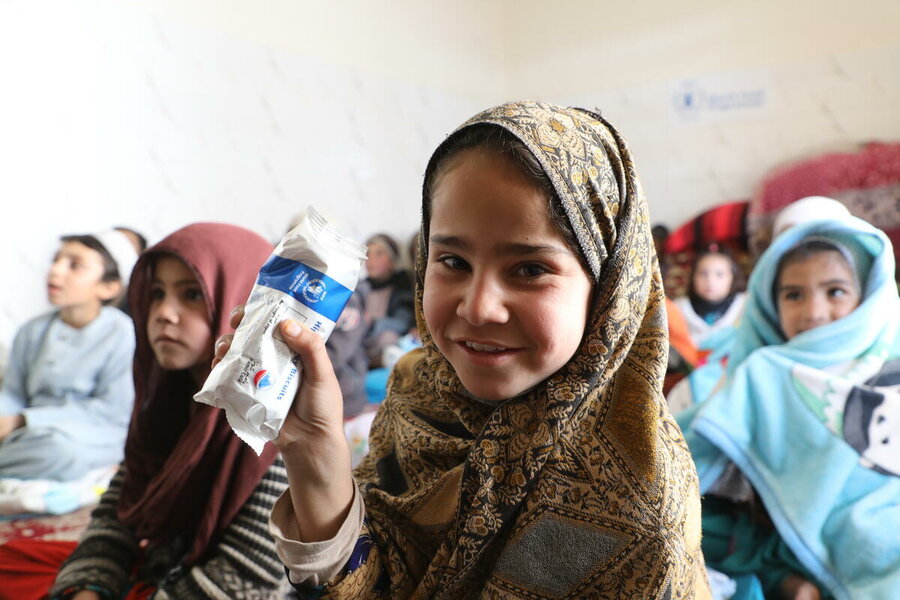 A girl holds up a meal bar