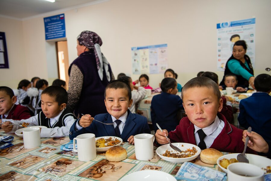 Boys sitting at cafeteria table and eating 