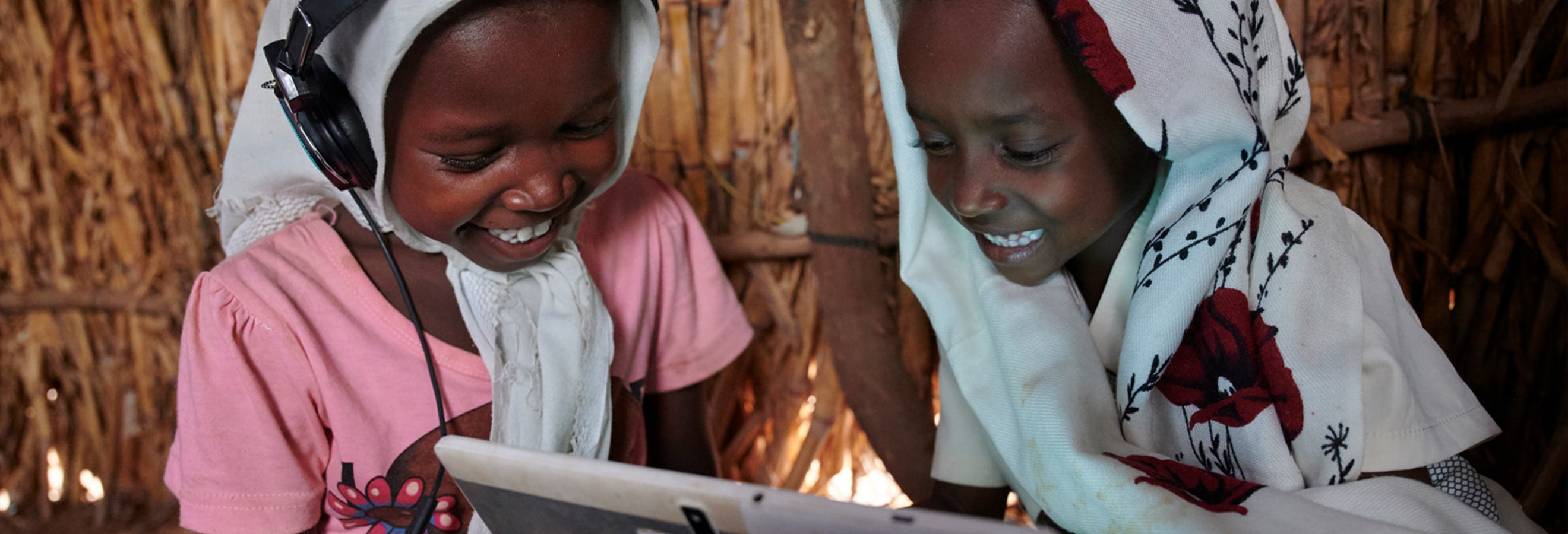 Three students smile in schoolyard