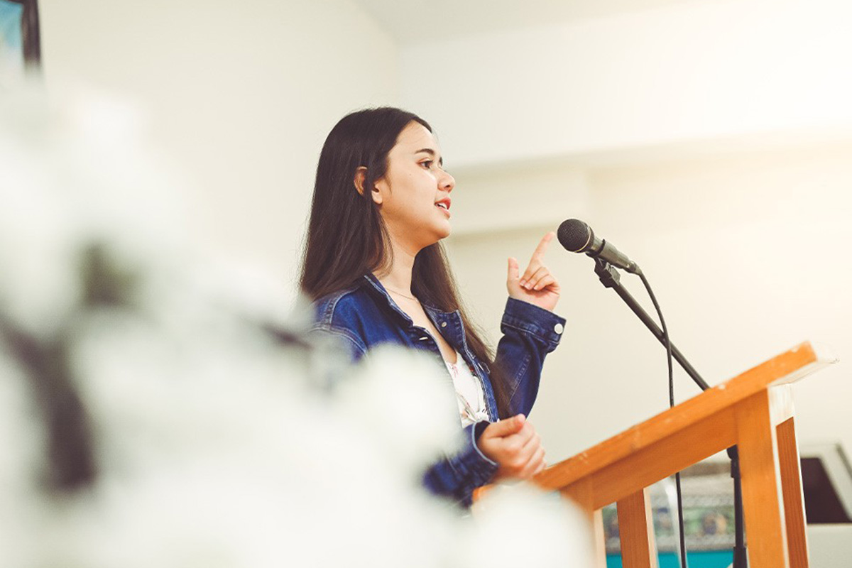 A young woman speaking at a podium