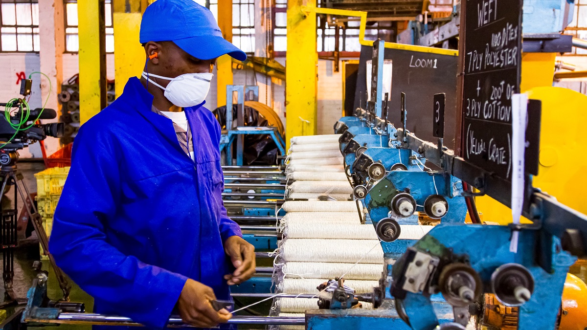 A factory worker winding thread. 
