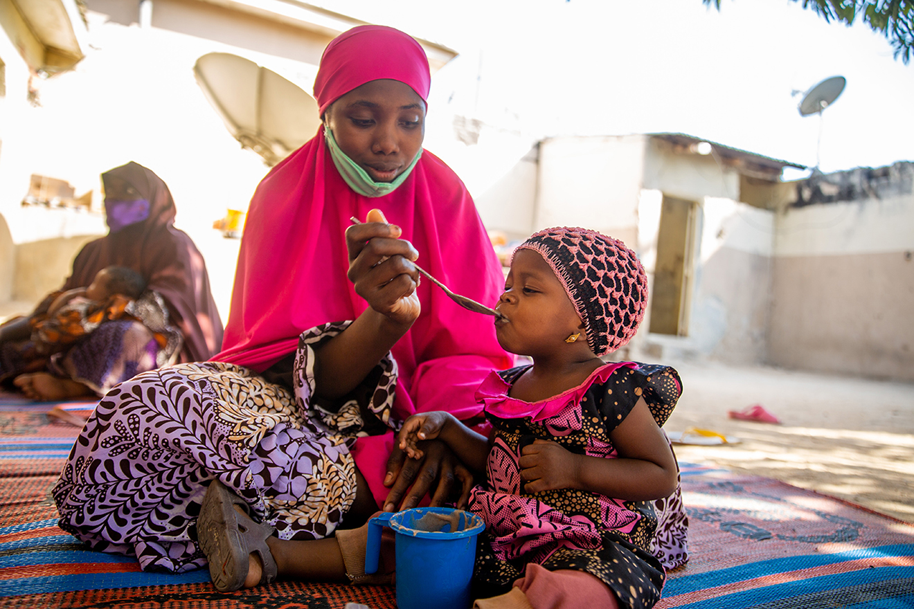 A woman feeding a baby