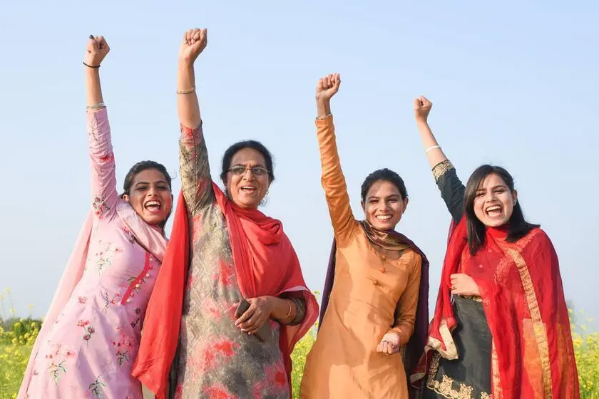 Jasbeer and her three adult daughters holding up fists.