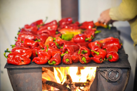 Red peppers roasting over an oven
