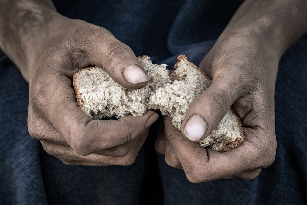 Close-up of hands tearing a slice of bread 