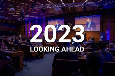 A conference room where a meeting is being held overlayed with the words: 2023 Looking Ahead