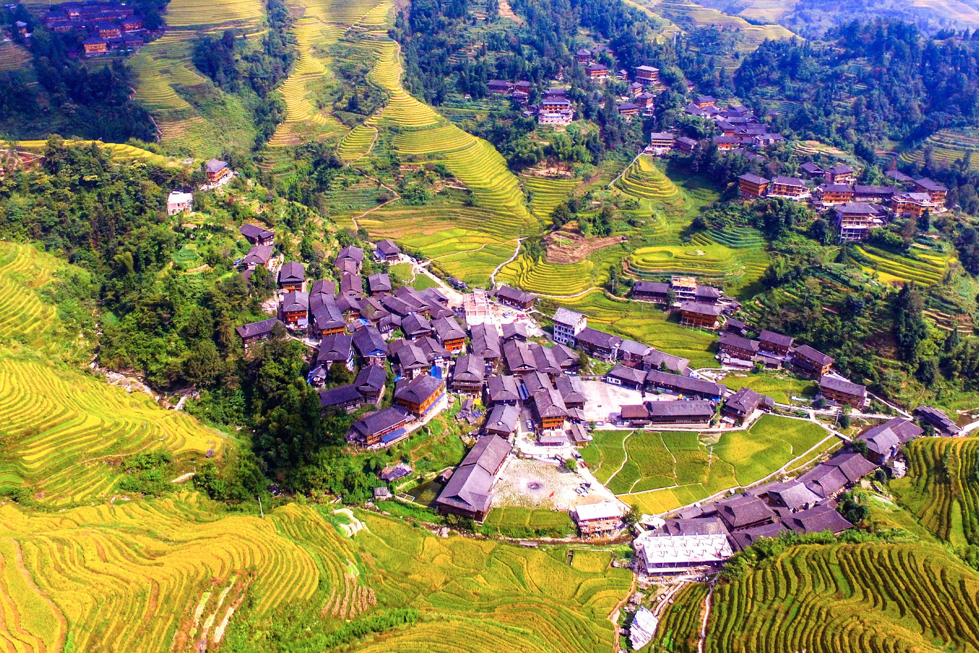 A mountain village surrounded by farming terraces.