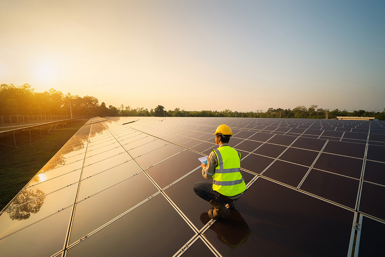 a man working on a solar panel in a solar farm