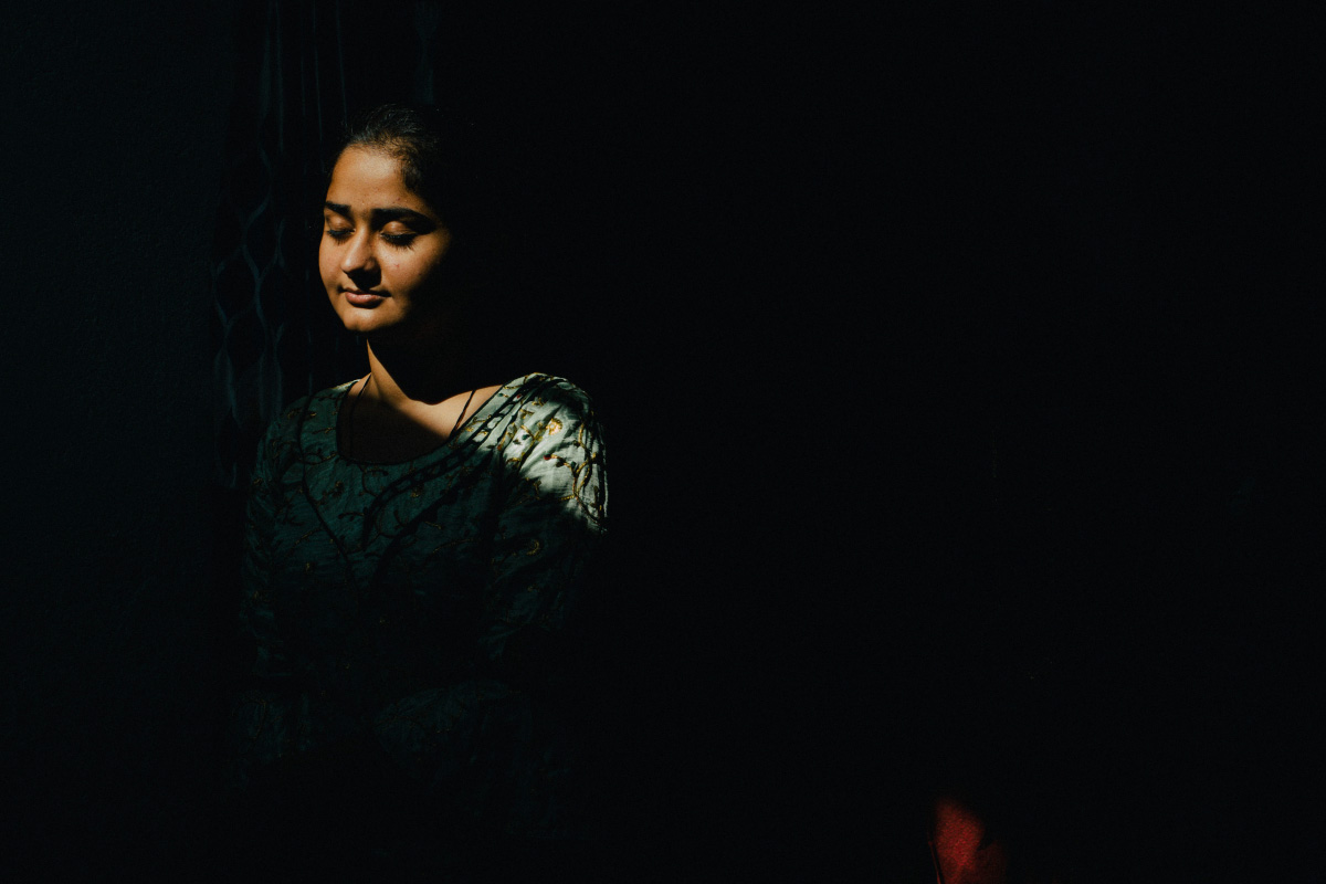 Portrait of Divya in the dark with her eyes closed