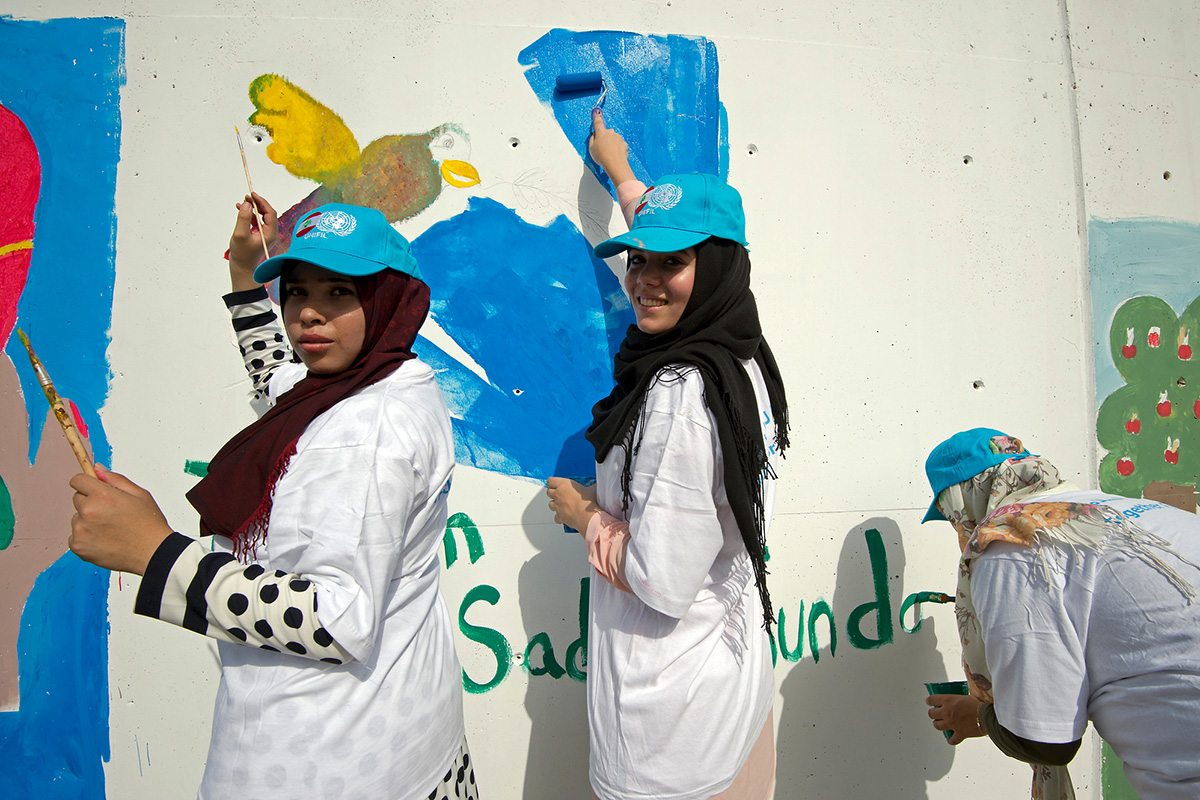 Young women painting a mural at UNIFIL HQ to celebrate the International Day of Peace
