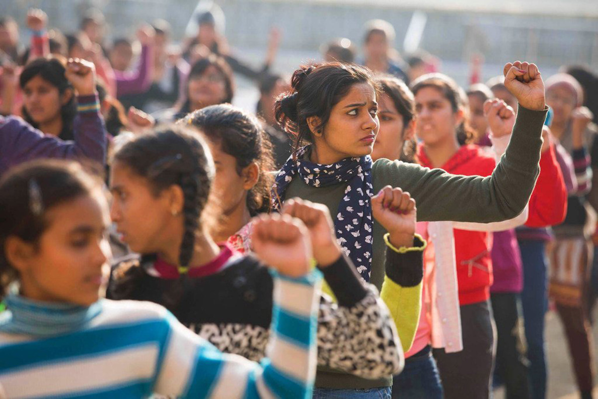 Girls march raising their fists