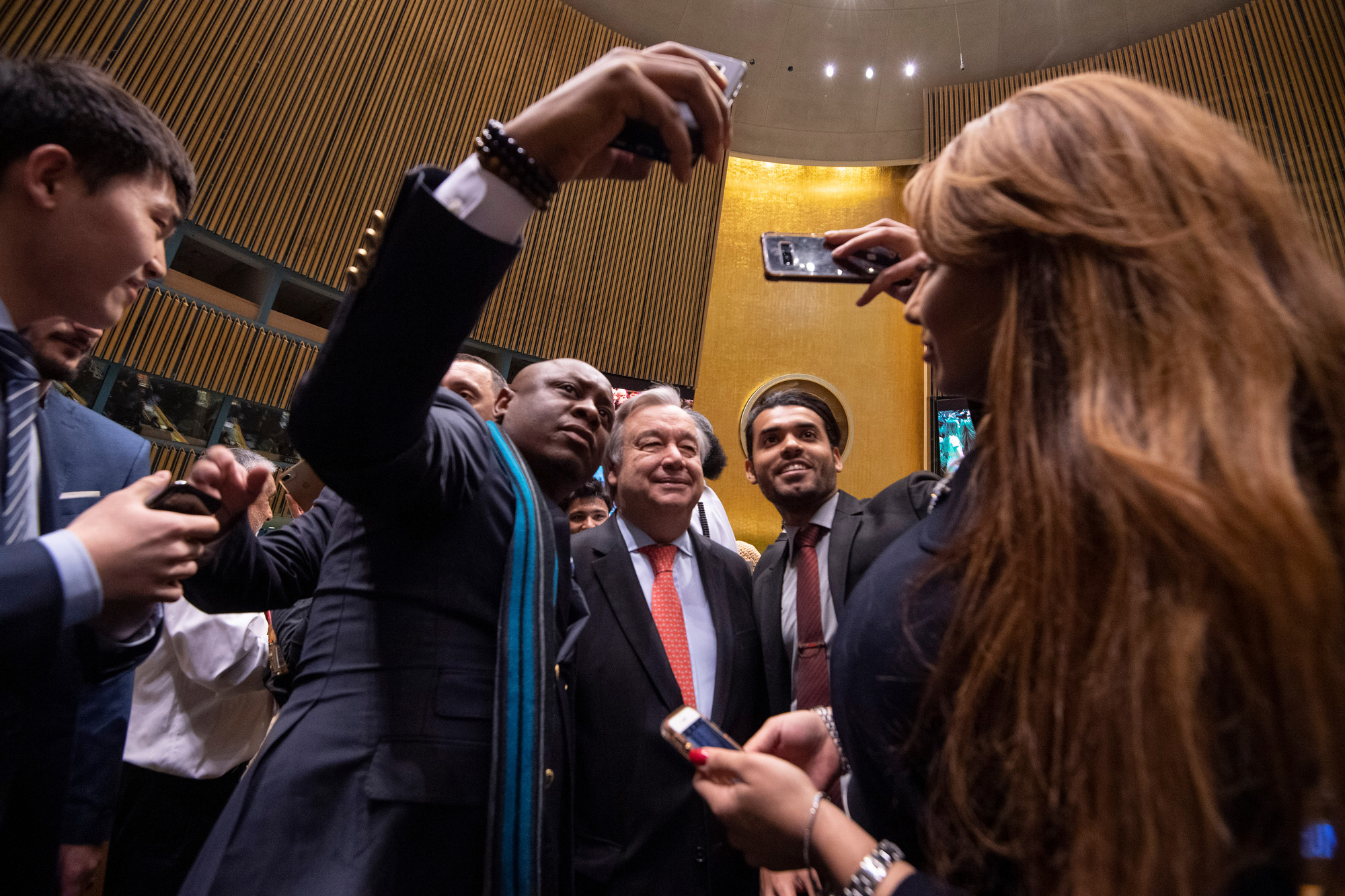 The Secretary-General poses for selfies with UNA-USA members in the General Assembly Hall.