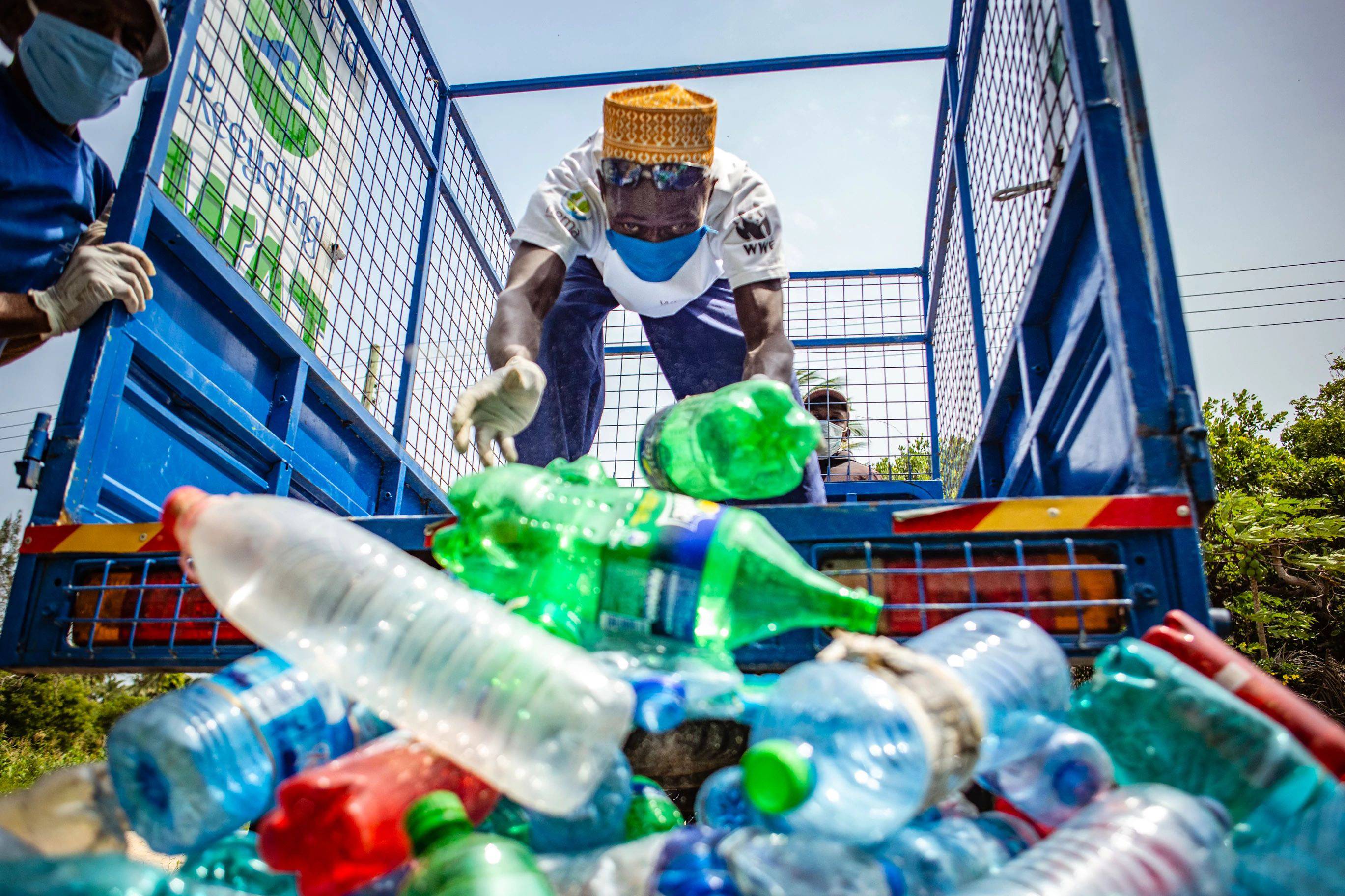 a person unloading plastic bottles from the back of a truck