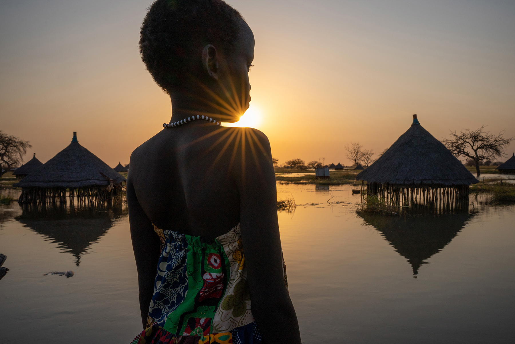 girl looks on flooded village