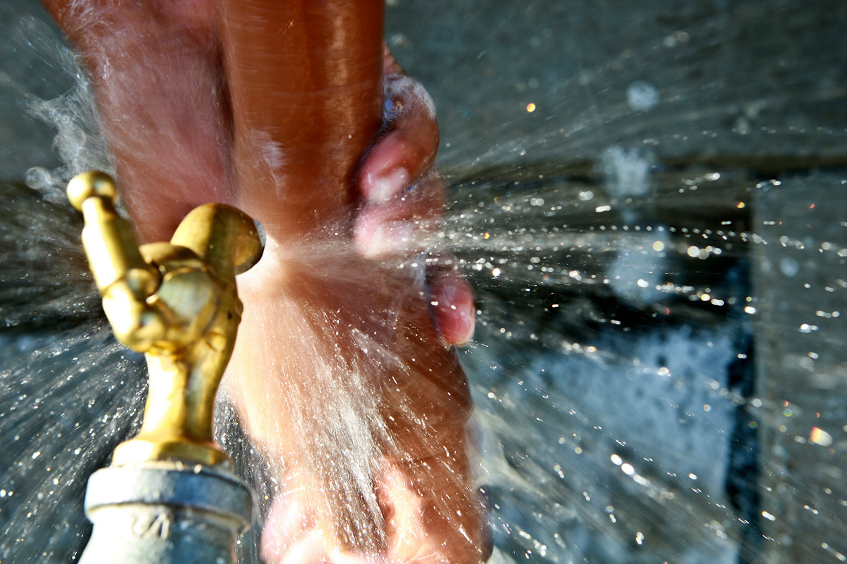 View from above of a tap flowing water onto hands