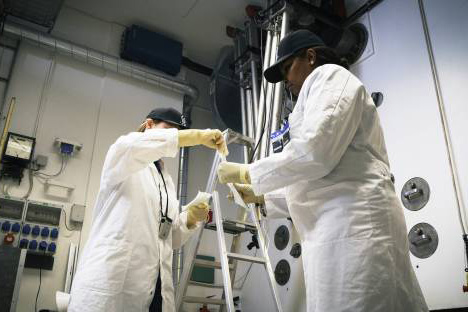 Two women in lab coats collecting samples.