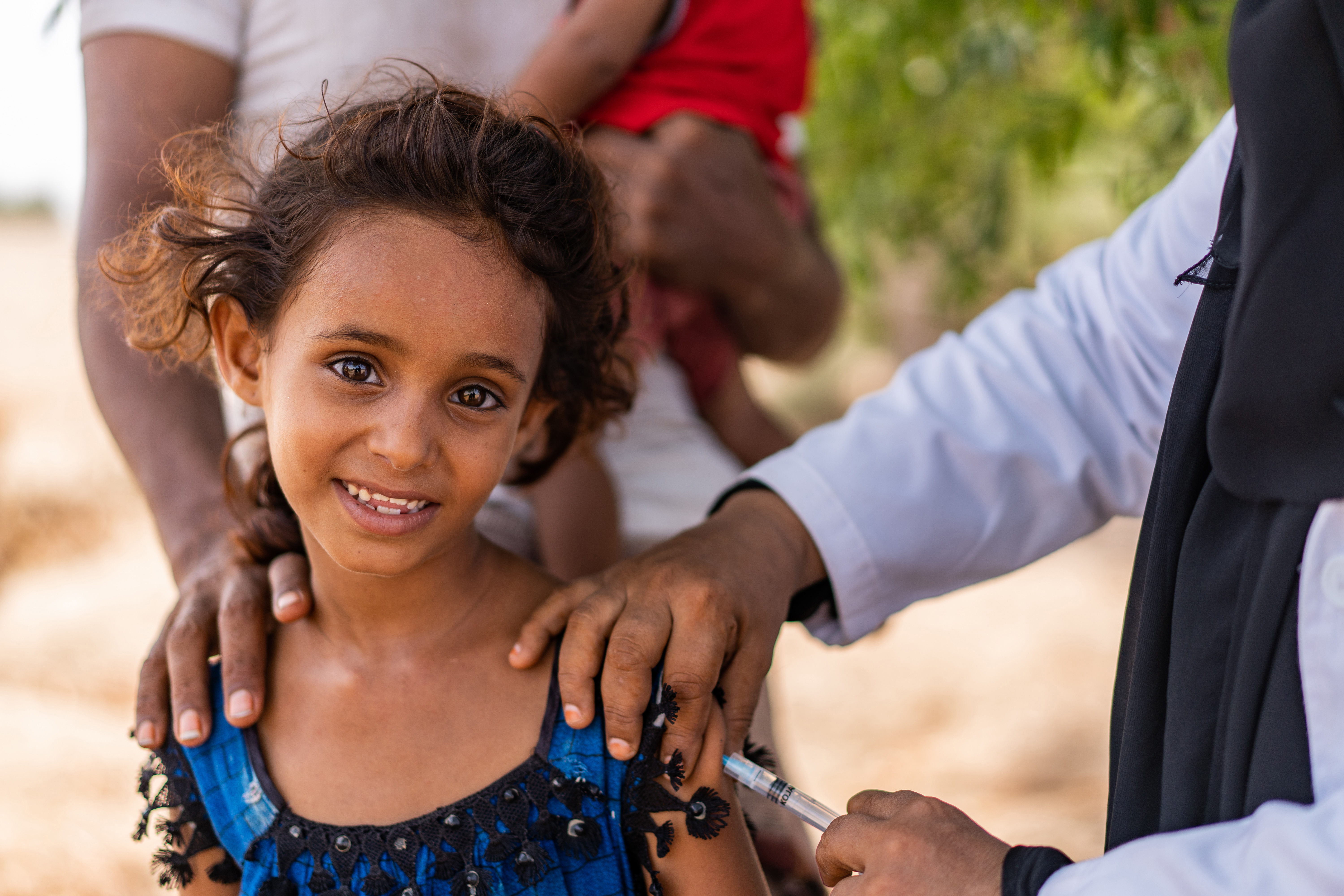 A girl smiles while taking vaccine