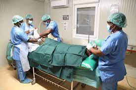 Des Casques bleus se préparent à opérer un patient à l’intérieur du module chirurgical mobile léger